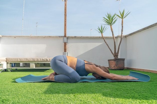 Giovane donna che fa yoga fuori