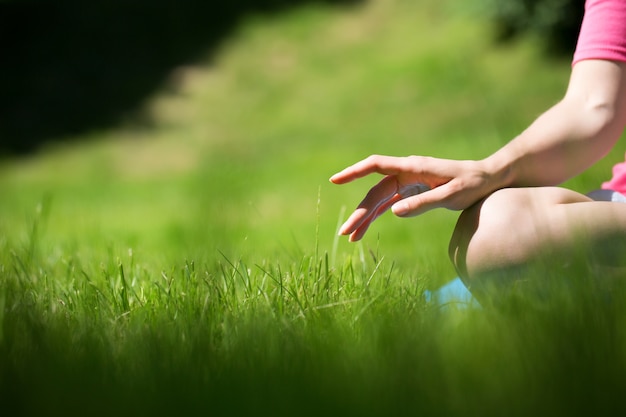 Giovane donna che fa yoga nel parco