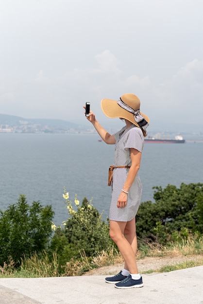 Giovane donna che fotografa il paesaggio urbano utilizzando il telefono cellulare