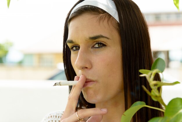 Giovane donna che fuma una sigaretta