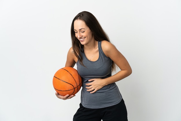 Giovane donna che gioca a basket su sfondo bianco isolato sorridente molto