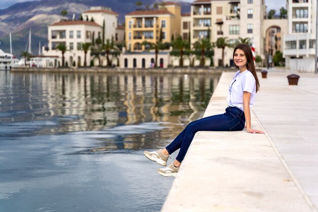 Giovane donna che gode della vista del mare in un porto Montenegro del porticciolo