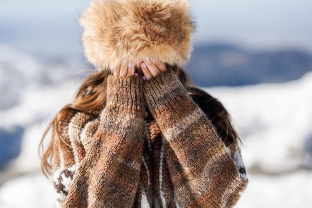 Giovane donna che gode delle montagne nevose in inverno