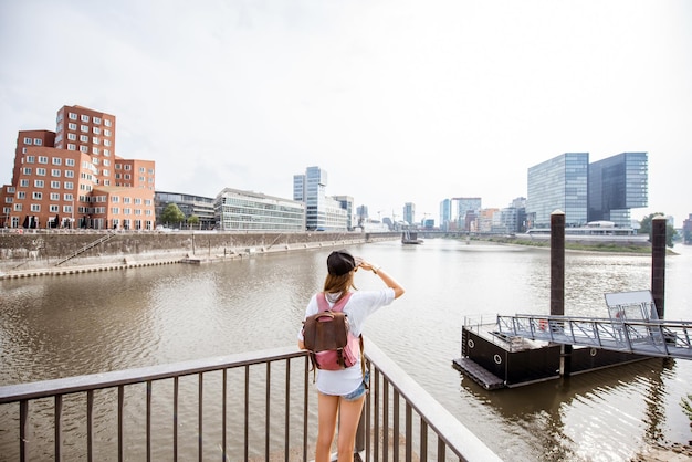 Giovane donna che gode di una splendida vista sul porto con edifici moderni nella città di Dusseldorf, Germany