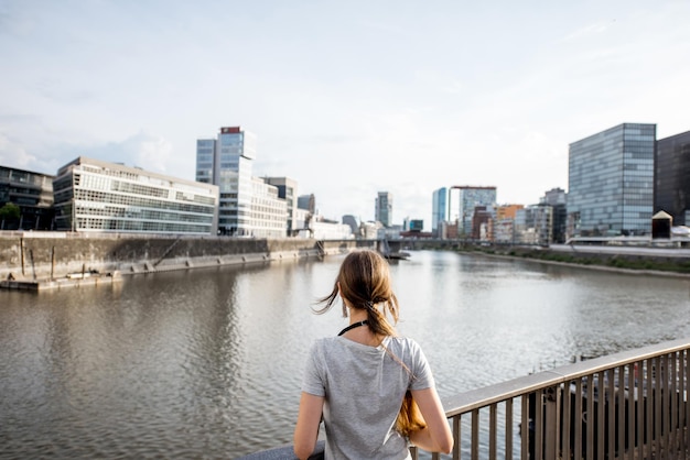 Giovane donna che gode di una splendida vista sul porto con edifici moderni nella città di Dusseldorf, Germany