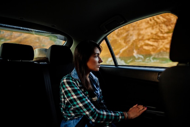 Giovane donna che guarda attraverso il finestrino dell'auto
