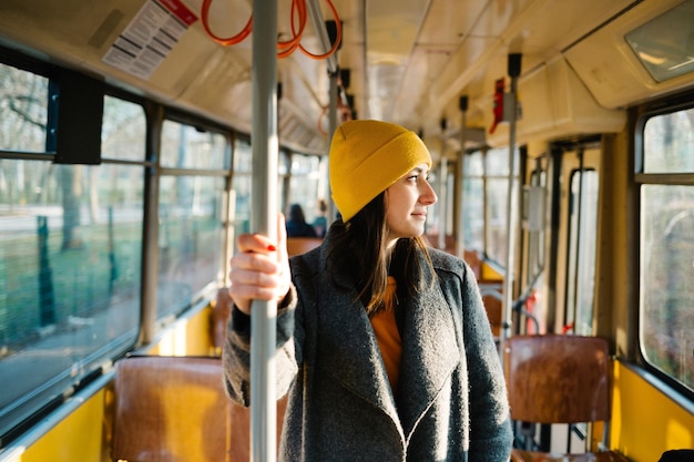 Giovane donna che guarda attraverso la finestra del tram