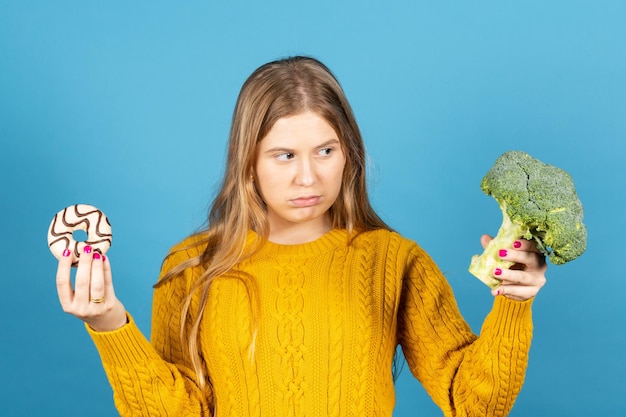 Giovane donna che guarda con frustrazione i broccoli