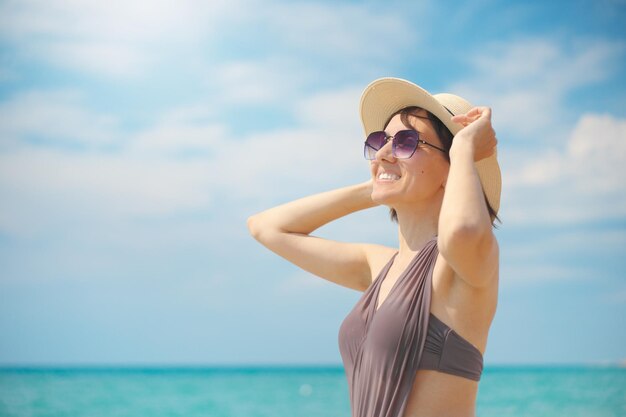 Giovane donna che guarda il mare con il cappello di giorno Rilassarsi e la scena della natura