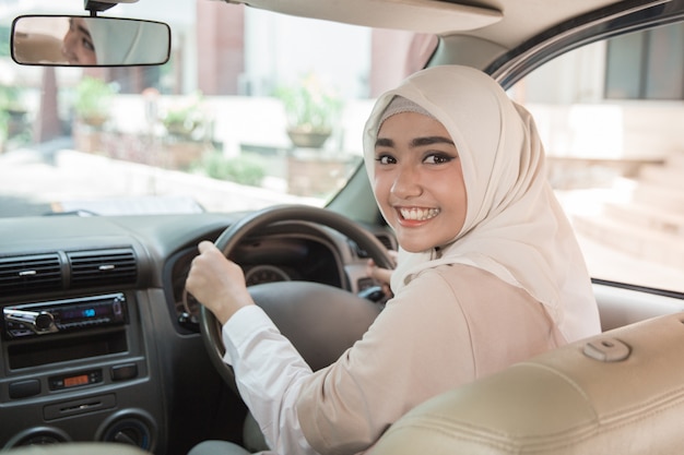 Giovane donna che guida la sua auto