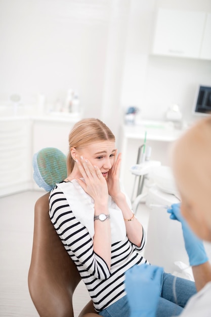 Giovane donna che ha paura delle cure odontoiatriche