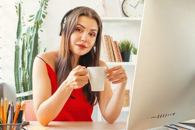 Giovane donna che ha una pausa caffè mentre era seduto nel suo ufficio