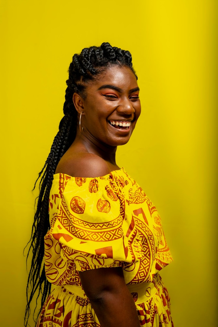 Foto giovane donna che indossa abiti lunghi colorati su sfondo giallo espressione naturale