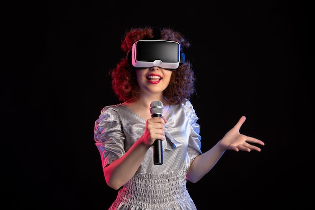 Giovane donna che indossa le cuffie da realtà virtuale con microfono