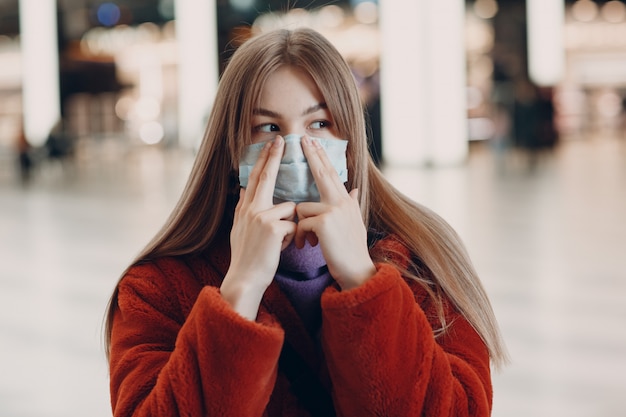 Giovane donna che indossa maschera medica all'interno