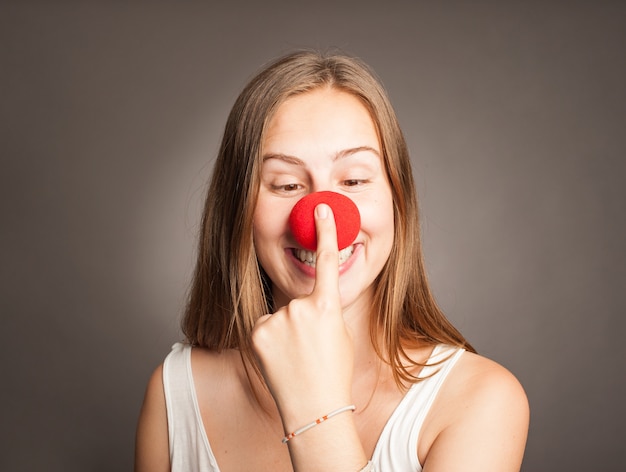 Giovane donna che indossa un naso da clown