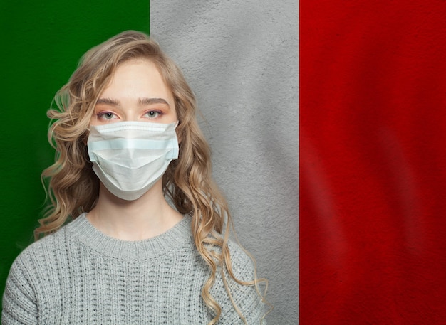 Giovane donna che indossa una maschera con la bandiera nazionale italiana Concept di protezione contro l'epidemia di influenza e il virus