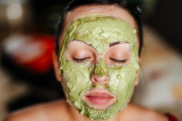 Giovane donna che indossa una maschera facciale. Concetto di cura della pelle