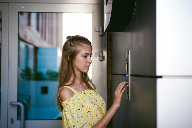 Giovane donna che inserisce la password sul sistema di sicurezza della porta