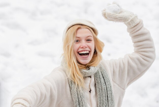 giovane donna che lancia una palla di neve all'aperto