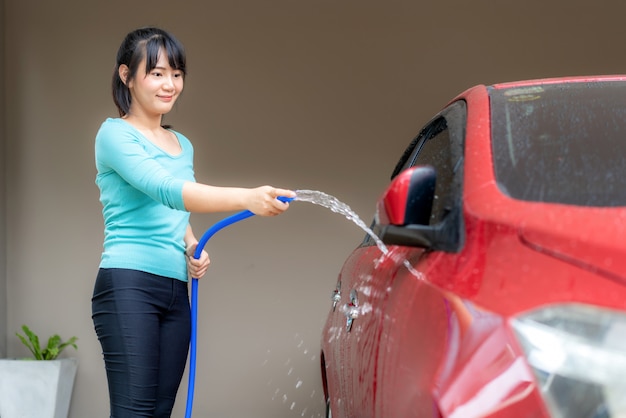 Giovane donna che lava una macchina