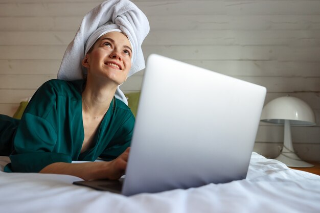 Giovane donna che lavora al computer dopo la doccia