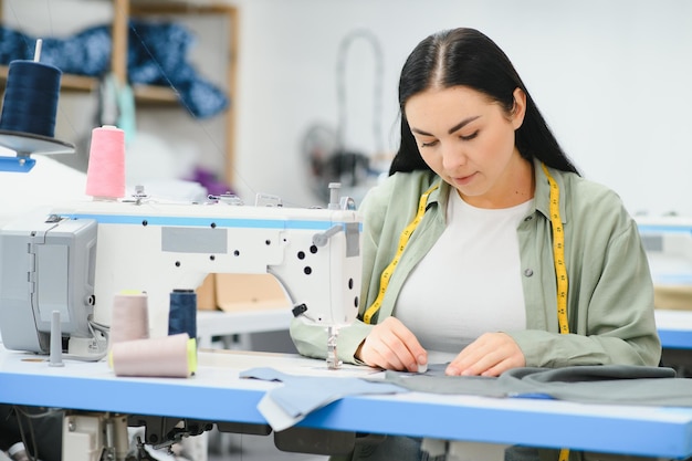 Giovane donna che lavora come sarta nella fabbrica di abbigliamento