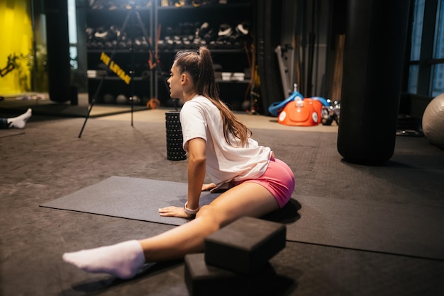 Giovane donna che lavora facendo esercizio di yoga o pilates