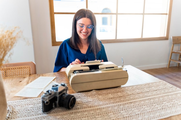 Giovane donna che lavora focalizzata sulla macchina da scrivere