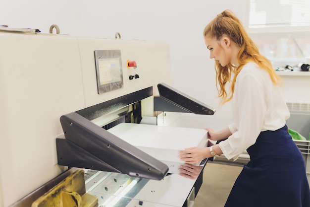 Giovane donna che lavora nella fabbrica di stampa. Stampa.