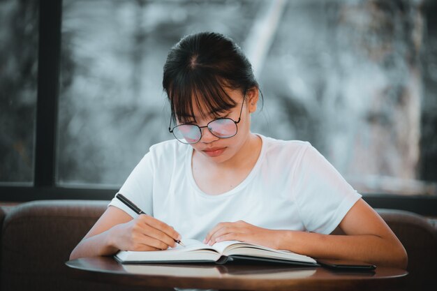 Giovane donna che legge seriamente un libro in caffetteria. Concetto. Concetto. formazione scolastica