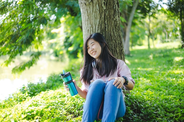 Giovane donna che legge un libro in estate natureA donna che legge un libro all'aperto