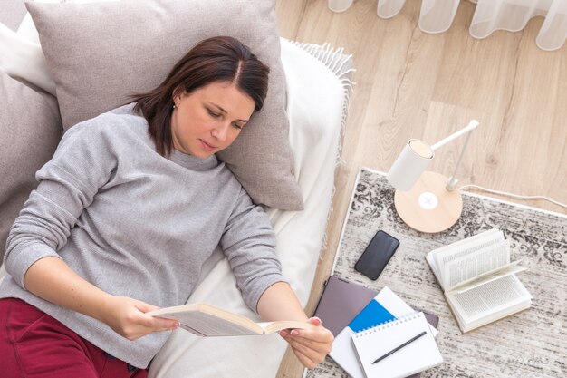 Giovane donna che legge un libro mentre si rilassa