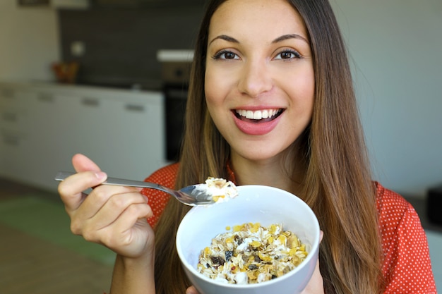 Giovane donna che mangia frutta e muesli di cereali