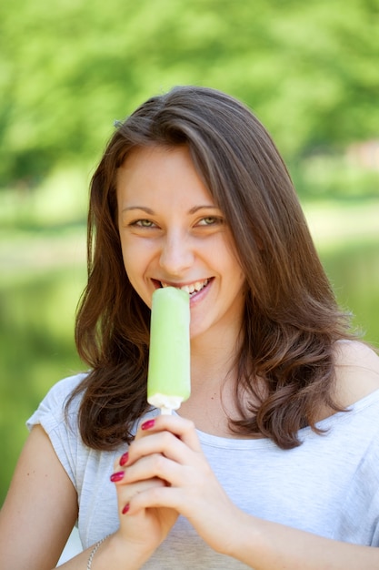 Giovane donna che mangia il gelato giornata di sole all'aperto