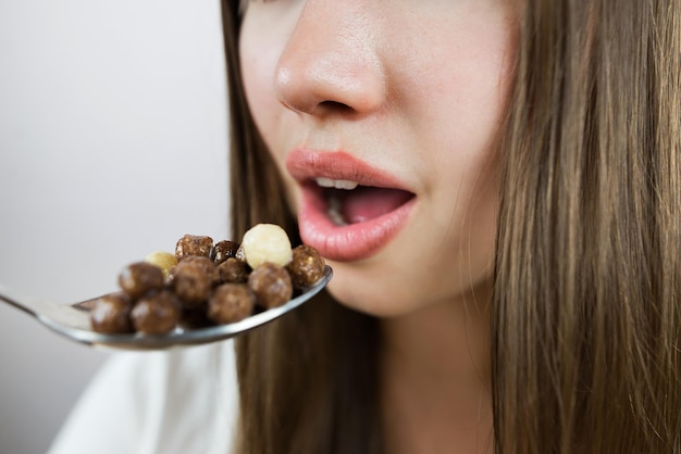 Giovane donna che mangia palle per la colazione