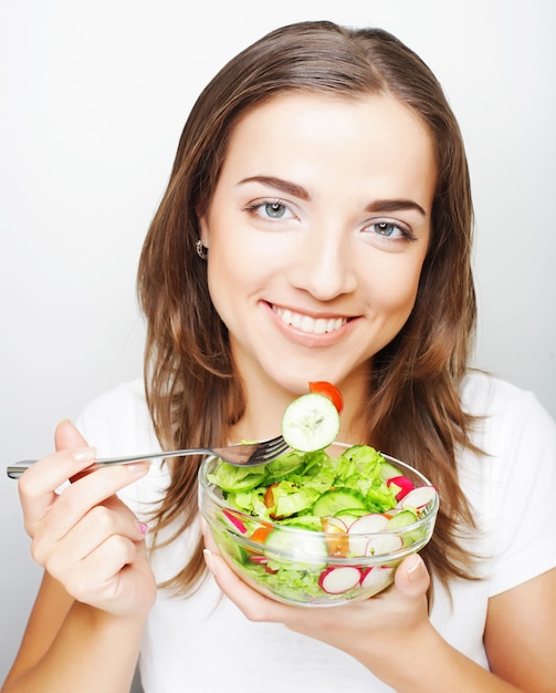 Giovane donna che mangia un'insalata