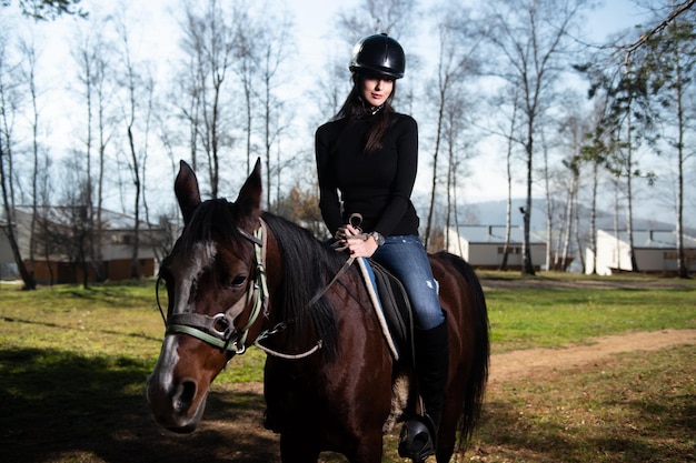 Giovane donna che monta un cavallo