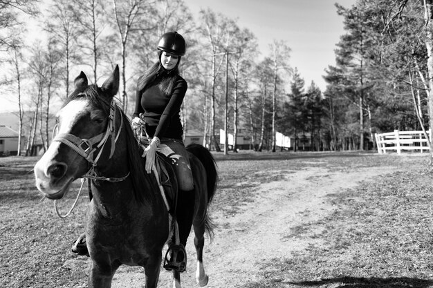 Giovane donna che monta un cavallo