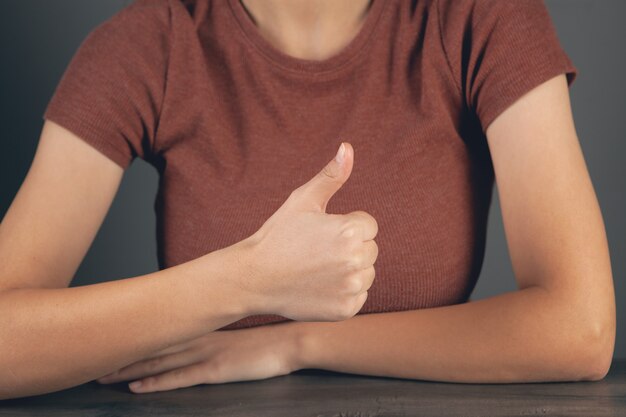 giovane donna che mostra i pollici in su