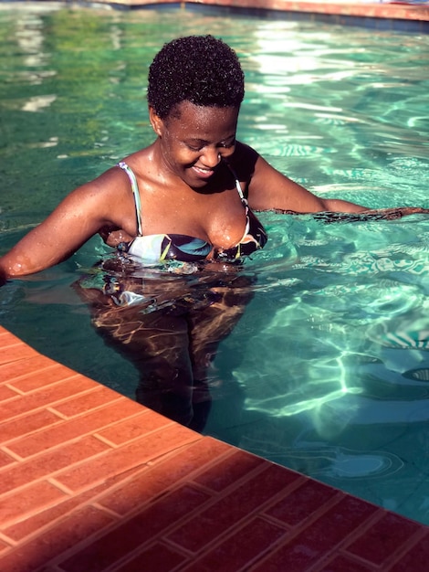Giovane donna che nuota in piscina