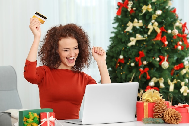 Giovane donna che ordina i regali di Natale online