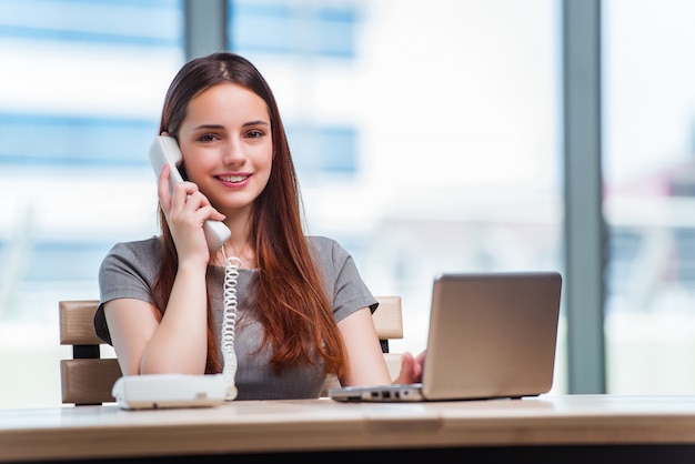 Giovane donna che parla sul telefono in ufficio