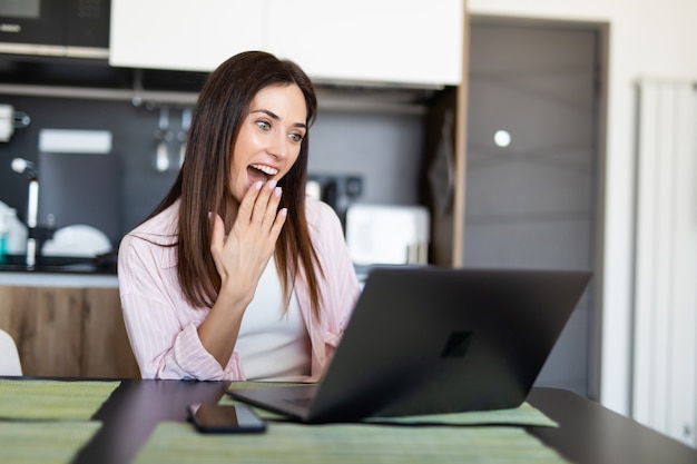 Giovane donna che per mezzo di un computer portatile