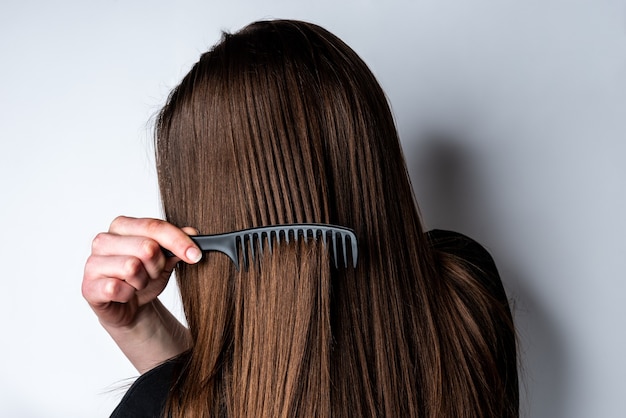 Giovane donna che pettina i suoi capelli.