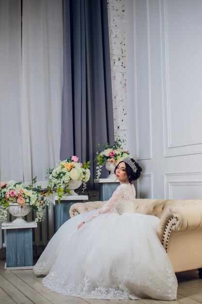 Giovane donna che posa con il bello vestito da sposa