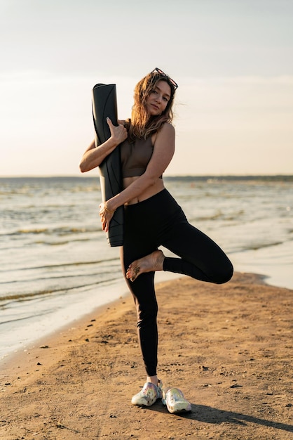 Giovane donna che pratica yoga asana all'aperto vicino al lago Uno stile di vita sportivo person039s Il trainer