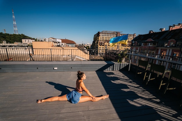 Giovane donna che pratica yoga sul tetto di un edificio