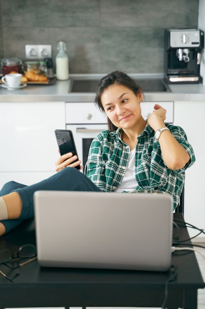 Giovane donna che prende selfie facendo uso dello smartphone a casa.