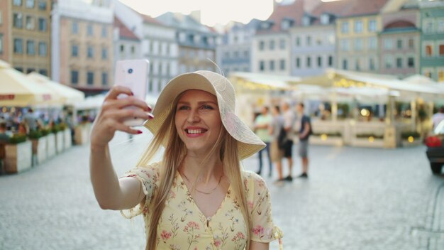 Giovane donna che prende selfie sul quadrato. Donna attraente che propone per il selfie